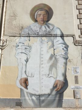Wandgemälde des Clowns Pierrot aus der italienischen Commedia dell'arte in weißem Gewand mit einem melancholisch-traurigen Gesichtsausdruck (Reproduktion eines Teils des Gemäldes "Pierrot, genannt Gilles" von Antoine Watteau)